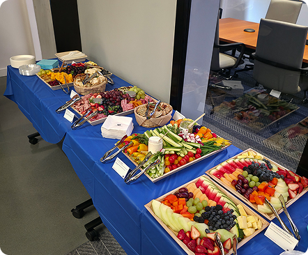 Refreshment table with fruit, vegetables, and snacks at an industry event.